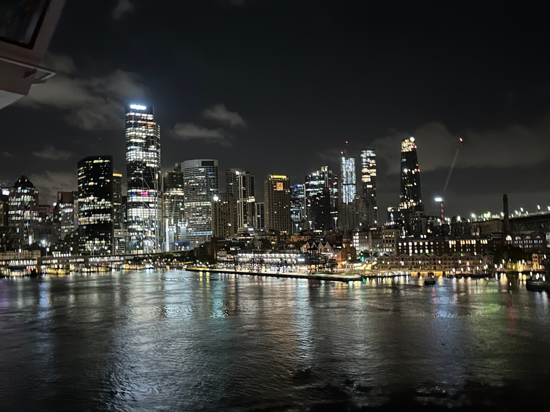 Sydney skyline glowing across the harbour at night
