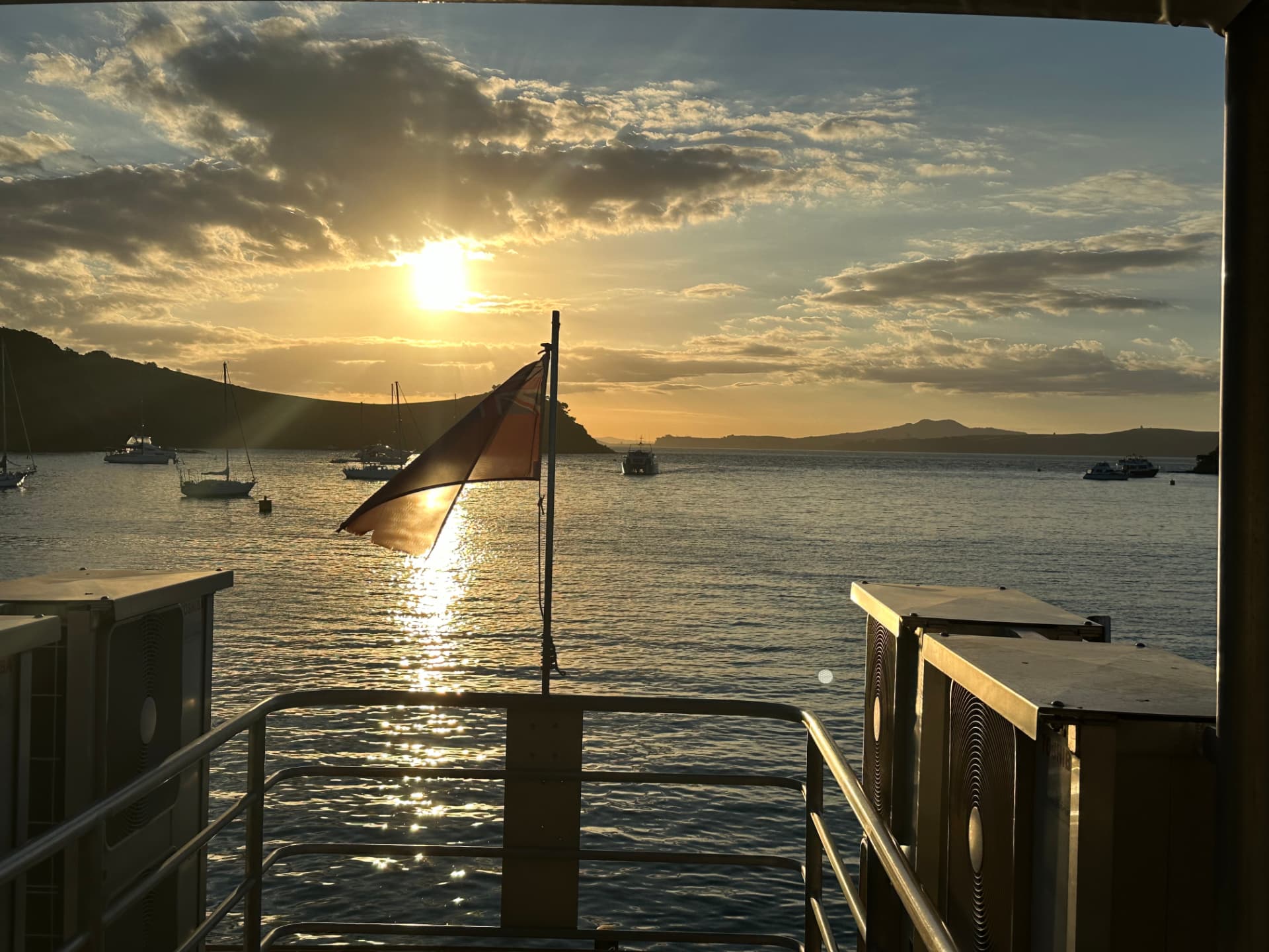 Sunset over a yacht-filled bay from the stern of a Waiheke Island ferry