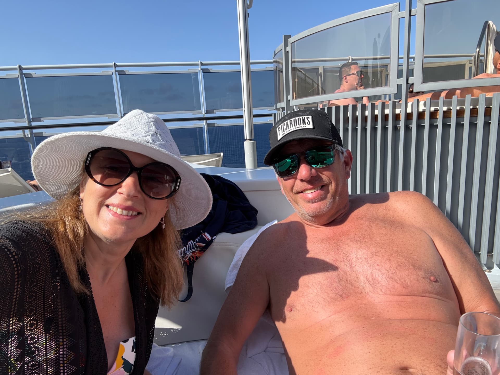 Natalia and her husband relaxing on a sunny cruise ship sun deck