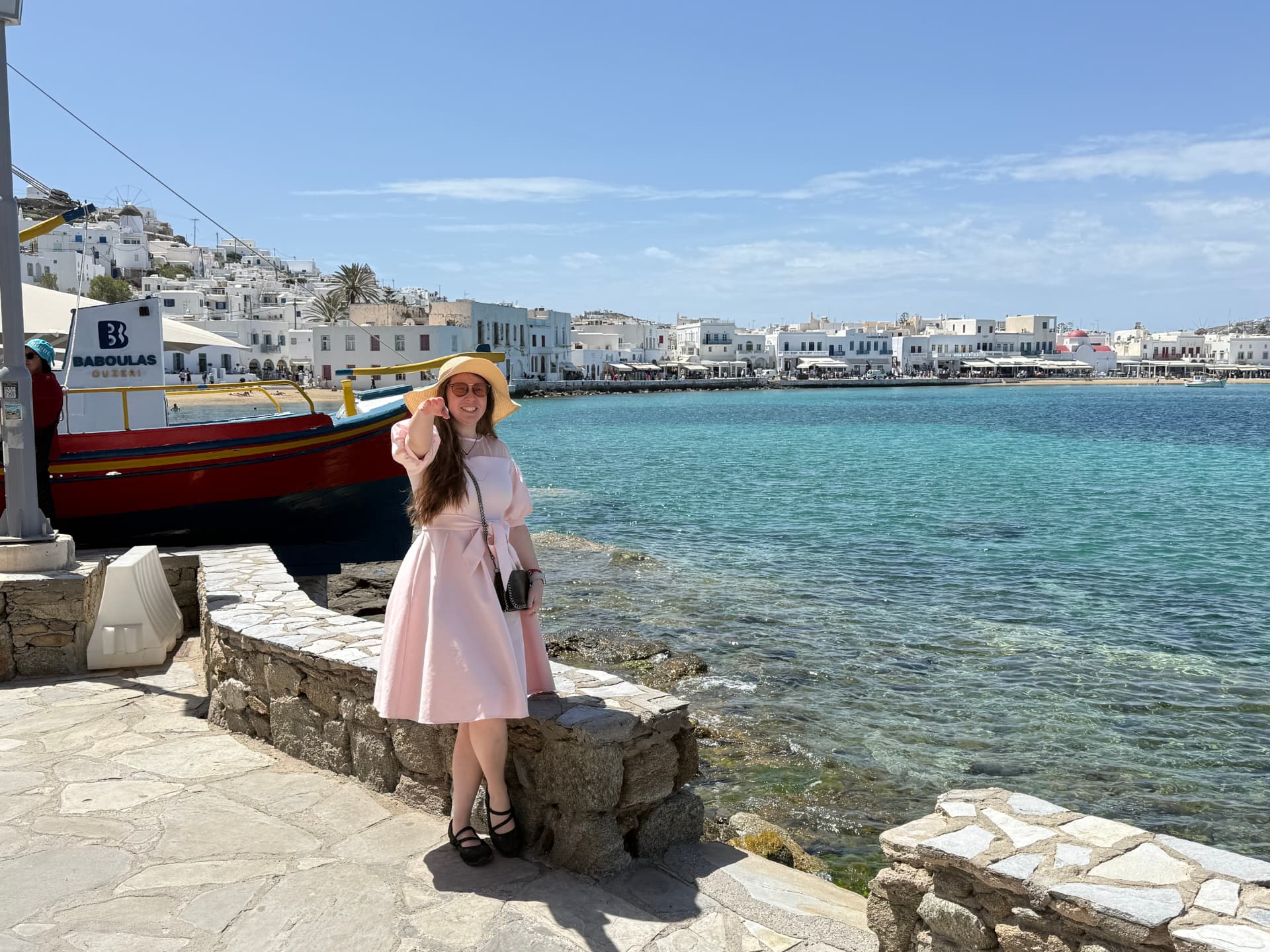 Natalia in Mykonos harbor with whitewashed town and turquoise water
