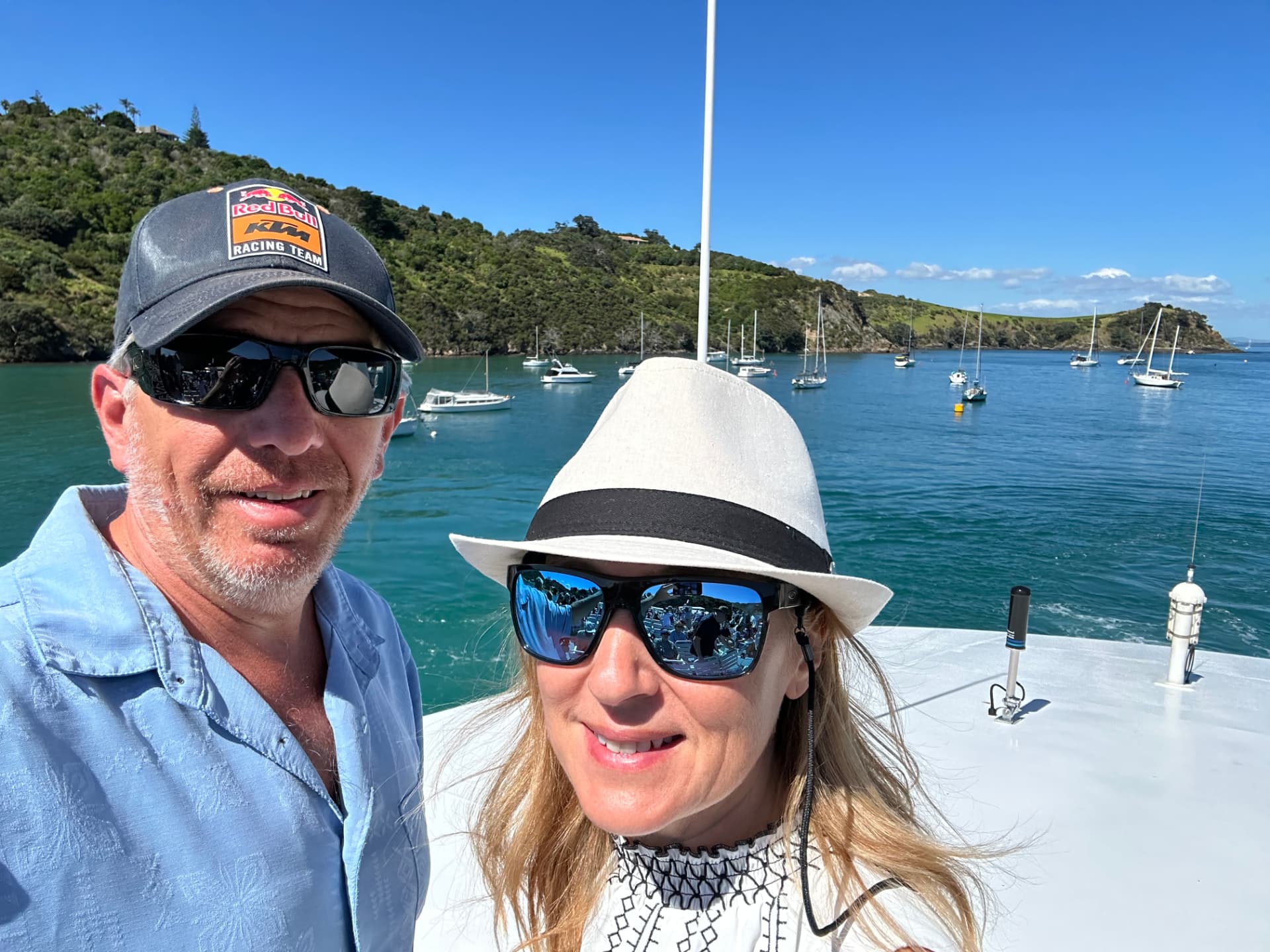 Natalia and her husband on a boat in a turquoise New Zealand bay