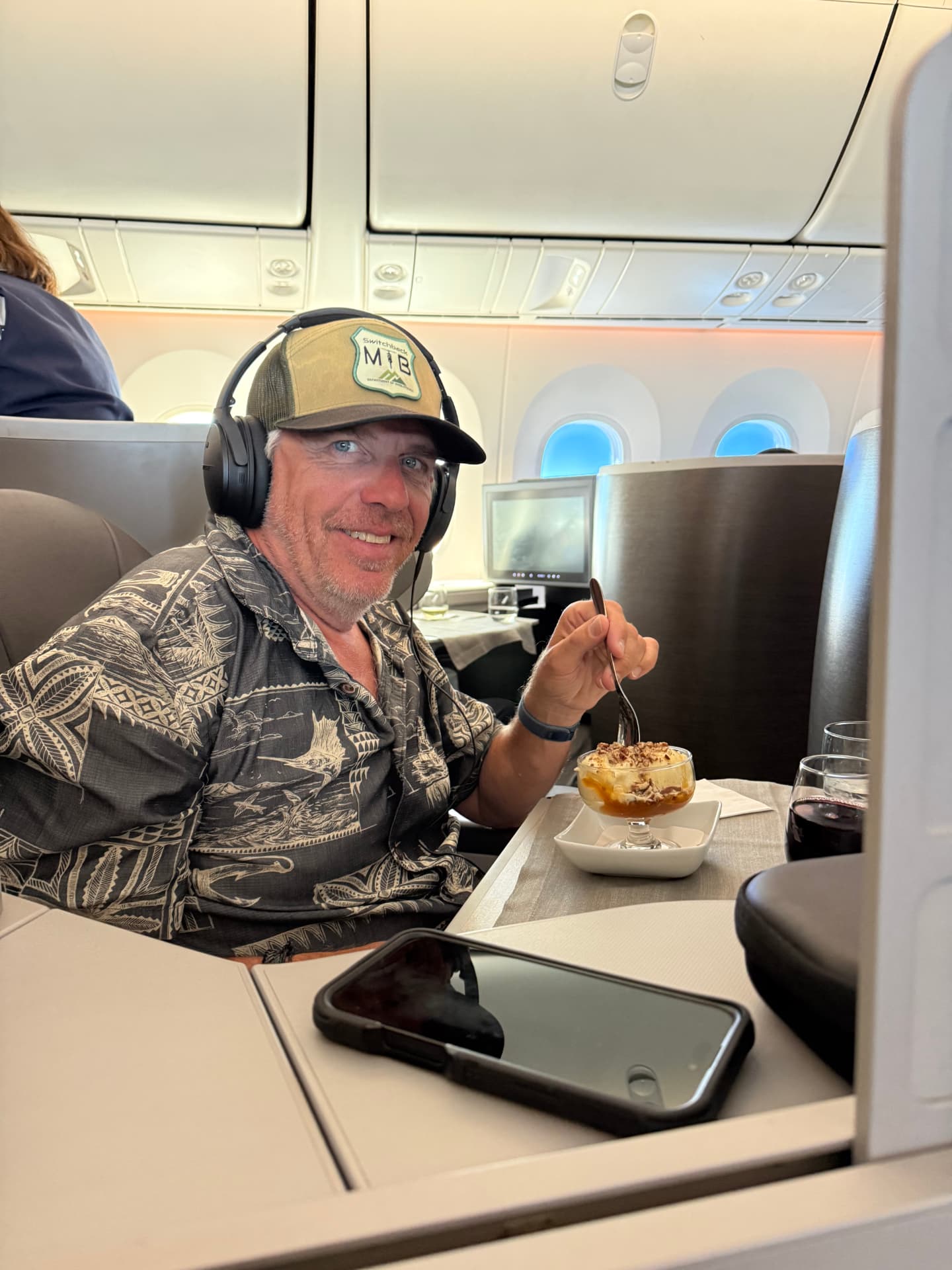Business class flyer enjoying dessert in a lie-flat seat
