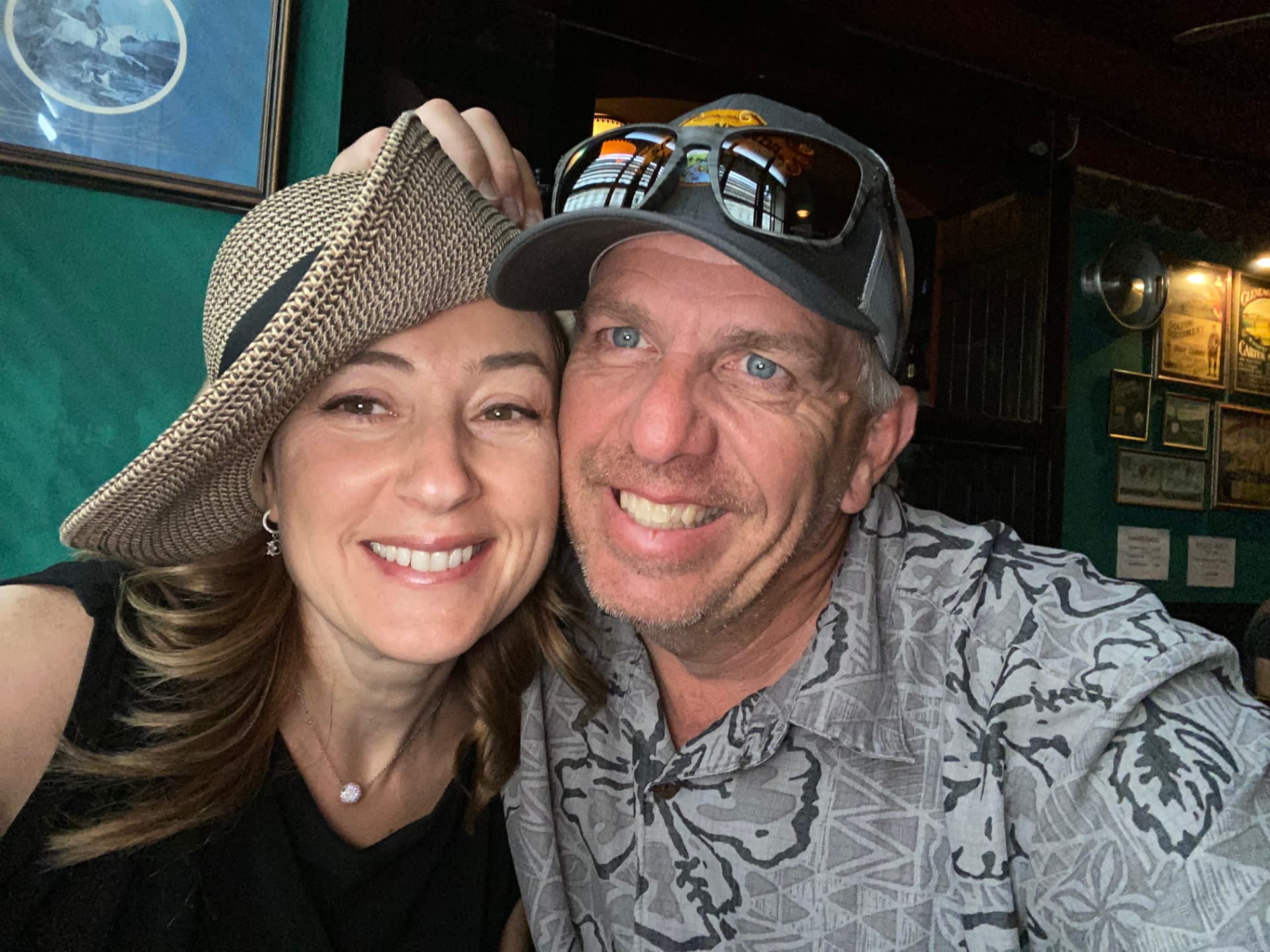 Natalia and her husband smiling in a cozy pub