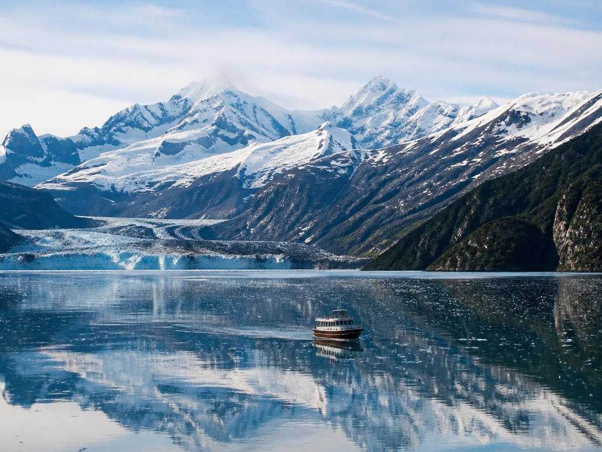 Alaskan glacier and snow-capped mountains reflected in still water